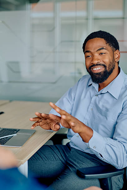 istock Black businessman talking and smiling during office meeting 2251535891