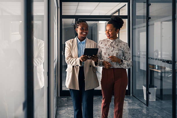istock Two Businesswomen Discussing Work While Walking in an Office Corridor 2251536748