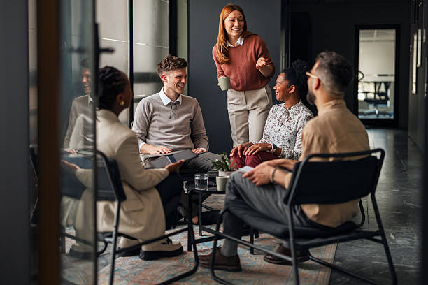 istock Group of Colleagues Socializing in a Relaxed Office Environment 2251537067
