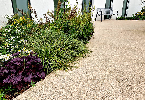 istock This image shows a modern garden design with ornamental plants, including a dominant sedge, like Japanese grass. A courtyard with light concrete. Arch-shaped flower bed, oshimensis 2251537707