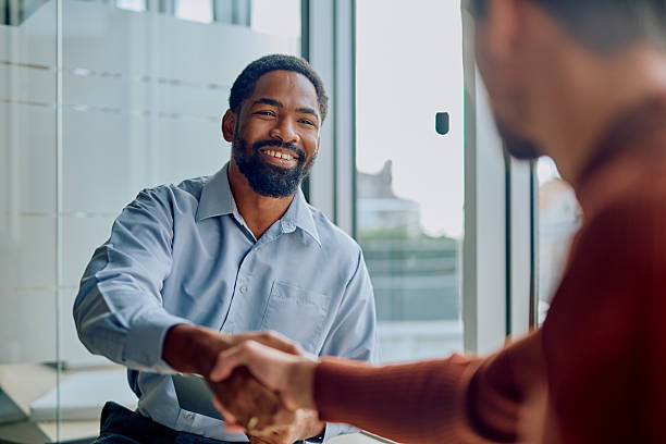 istock Businessmen shaking hands making partnership agreement in office 2251538636