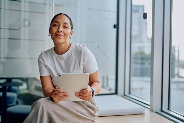 Woman smiling holding tablet in modern office