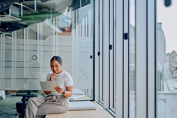 istock Professional woman using tablet casually in modern office 2251539198