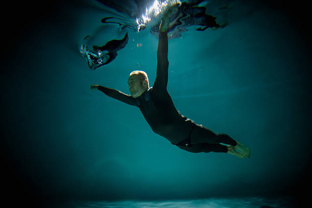 Senior free diver training under water in pool