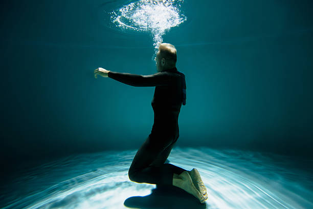 istock Senior diver in wetsuit training under water in swimming pool 2251543945