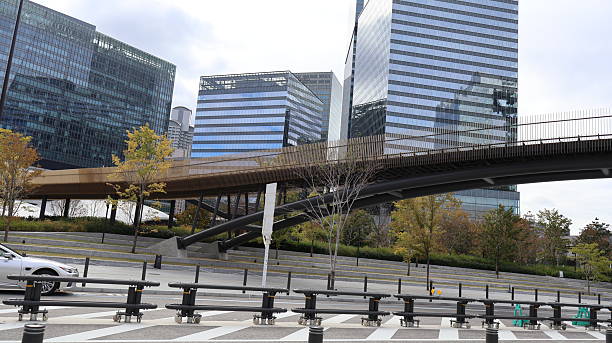 istock A bustling urban landscape with modern architecture featuring in the background. The foreground is dominated by an elevated highway overpass with a car traveling beneath it 2251545286