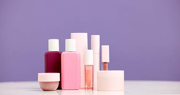 Makeup, container and product range in studio for beauty aesthetic, skincare routine and marketing. Space, cosmetic selection or bottles for dermatology, wellness or advertising on purple background.
