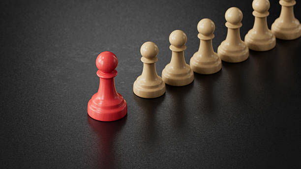 istock Solo Red Pawn Apart From Beige Pawns: Symbolizing Uniqueness 2251548264