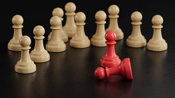 istock Standing & Fallen Red Pawns: Duality Among Beige Crowd 2251548266