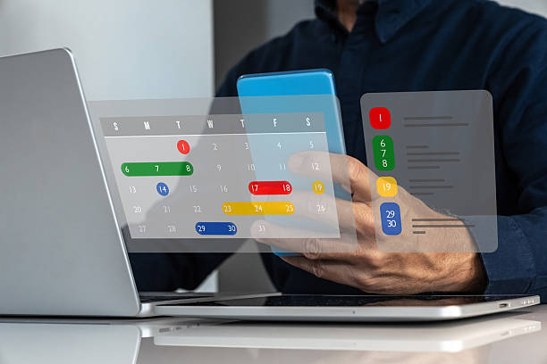 istock Business Professional Using a Smartphone and Laptop to Manage and Schedule Important Tasks via a Digital Holographic Calendar 2251548273