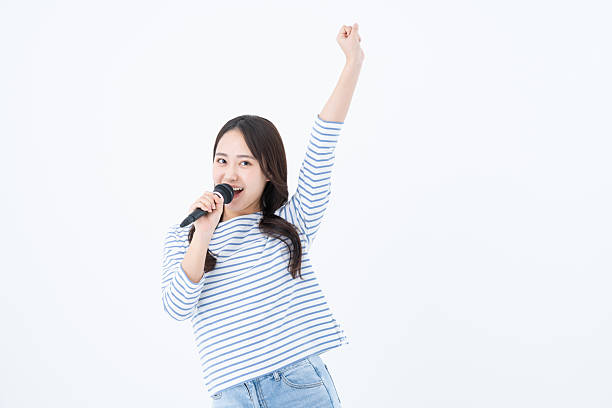 Young woman singing karaoke on white background