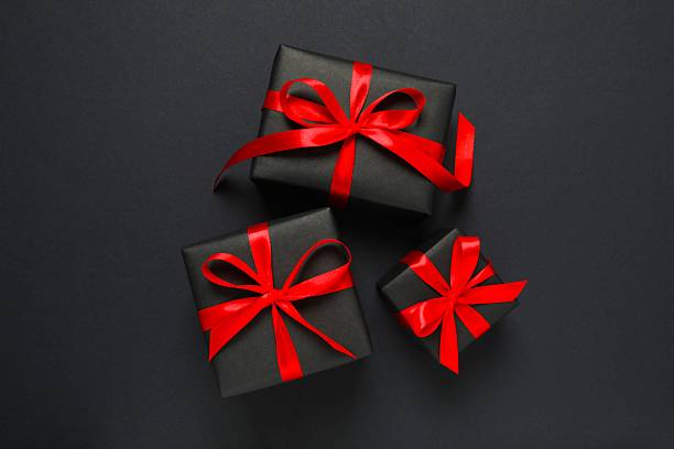 istock Beautiful gift boxes tied with bows on black background 2251549334