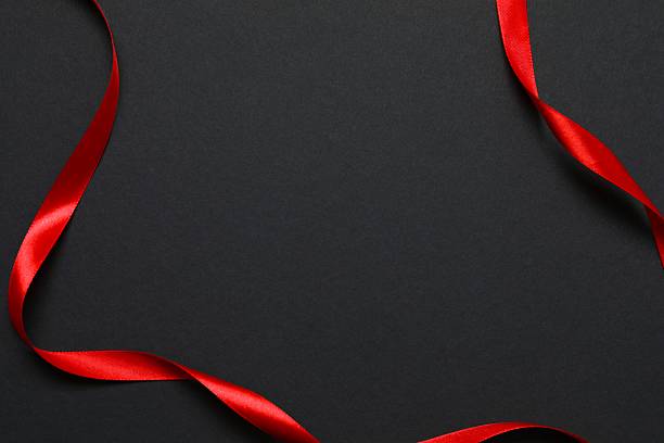 istock Stylish composition with red ribbon on black background, top view 2251549350