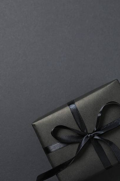 istock Beautiful gift box tied with bow on black background 2251549357