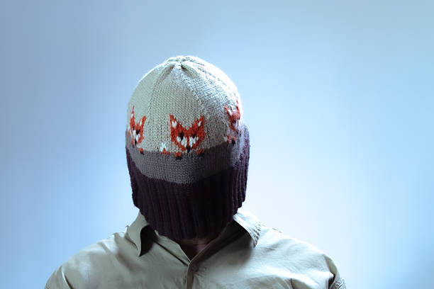 Man wearing a fox themed beanie over his face