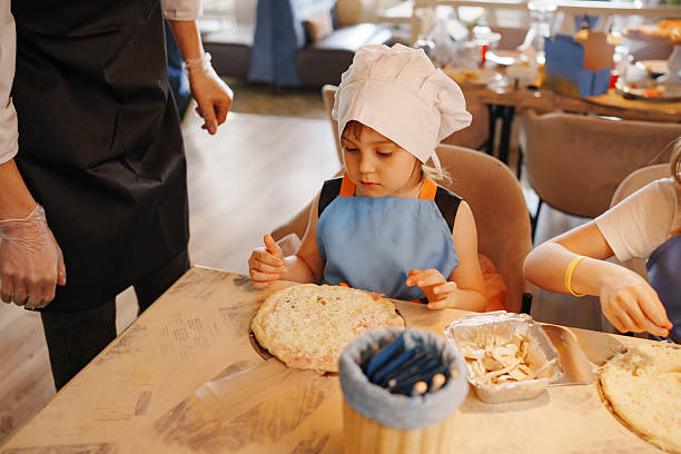istock Children making pizza in a bright cooking class setting 2251550213
