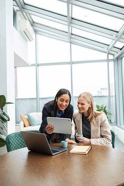 istock Diverse businesswomen collaborating using digital tablet in bright office 2251550854