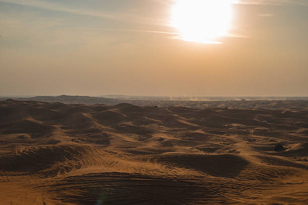 istock Vast, Undulating Desert Dunes Under a Hazy Golden Sky 2251551982
