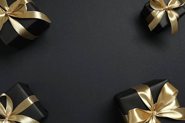 istock Beautiful gift boxes with a golden bows on black background 2251552366