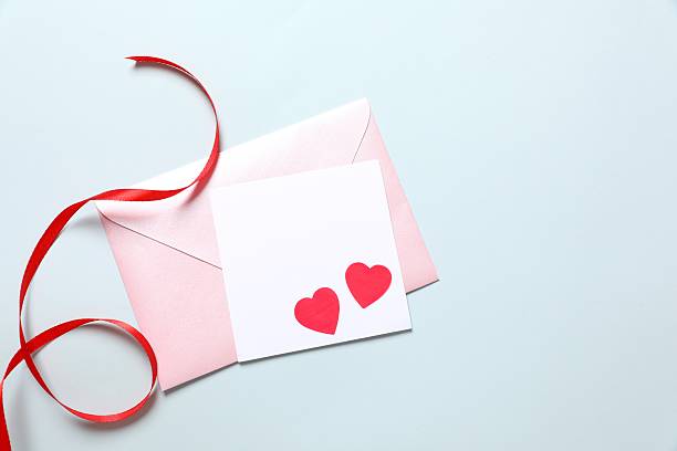 istock Pink paper envelope with blank white note mockup inside and Valentines hearts on color background. Flat lay, top view. Romantic love letter for Valentine's day concept. 2251552964