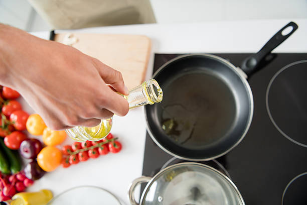 Cropped photo cooking man adding oil on frying pan