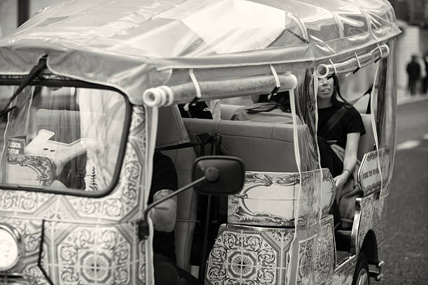 Lisbon, Portugal - October 29,2022: A tuk-tuk drives with tourists on board across Lisbon downtown.