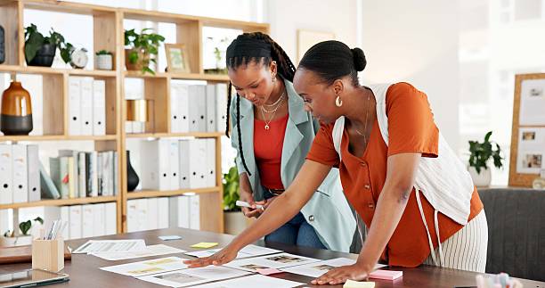 istock Team, documents and planning with business black women for campaign, project timeline and mindmap. Target audience briefing, branding pitch and brainstorming session with employees for meeting 2251558864