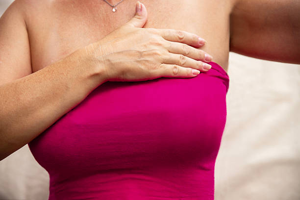 Woman performing breast self-examination at home for cancer awareness