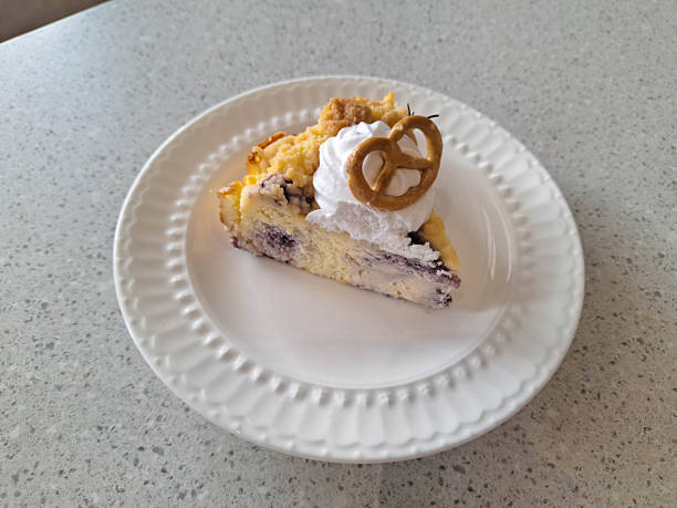 Blueberry Crumble Cheesecake with cream cheese,blueberries jam and pretzel on a plate. Dessert Menu.