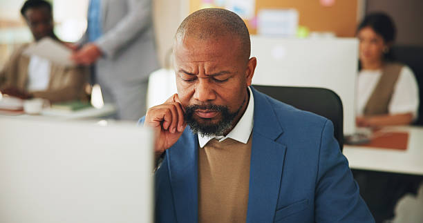 istock Businessman, computer and thinking with concern in office for 404 error, internet glitch or financial report issue. Confused, mature person and reading website for research or accounting mistake 2251566039