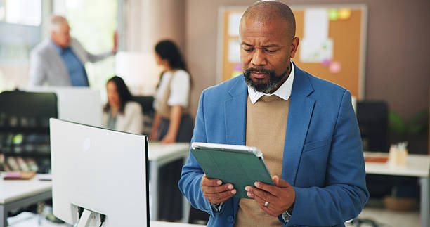 istock Business, man and reading with tablet in office for research, editing article and draft update. Mature person, coworking and digital to email editor, proofreading and submission for story publication 2251566094