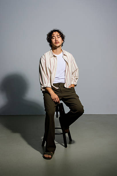 istock Stylish young Asian man  poses confidently on stool 2251571677
