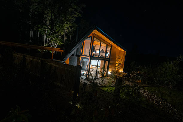 istock Modern Wooden House Illuminated at Night in Forest Setting 2251574227