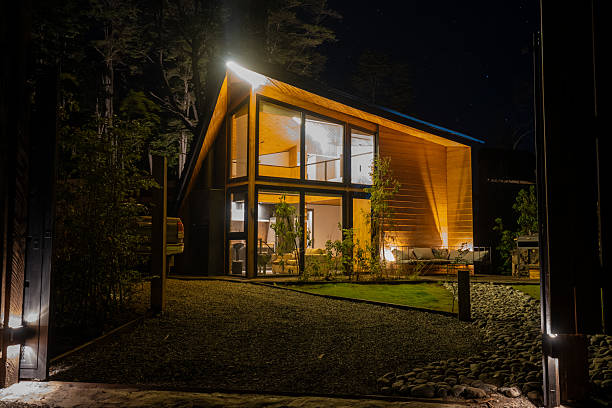 istock Modern Wooden House Illuminated at Night in Forest Setting 2251574247