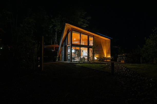 istock Modern Wooden House Illuminated at Night in Forest Setting 2251574275