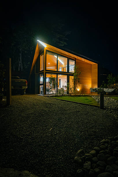 istock Modern Wooden House Illuminated at Night in Forest Setting 2251574290