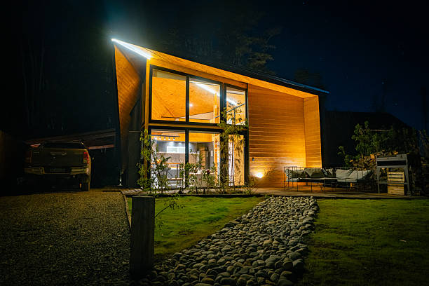 istock Modern Wooden House Illuminated at Night in Forest Setting 2251574457