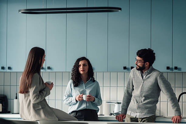 istock Coworkers having coffee break and casual conversation in office kitchen 2251584428