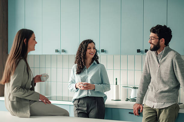 istock Coworkers enjoying coffee break and casual conversation in office kitchen 2251584527