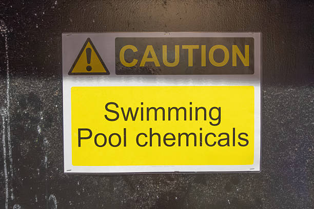 A yellow CAUTION Swimming Pool chemicals sign