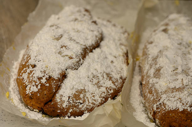 A rich,festive German Christmas Stollen curd cheese version displayed kitchen table. Dusted with powdered sugar decorated with dried fruits, this traditional holiday bread symbolizes Christmas warmth