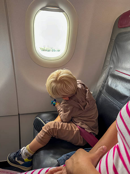 istock Young Caucasian Boy Engaging with Airplane Window View Excitedly 2251587549