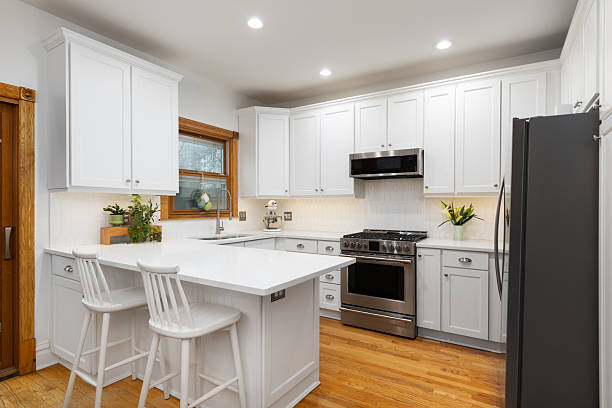 istock A white peninsula kitchen with hardwood floors and picket tile backsplash. 2251589074
