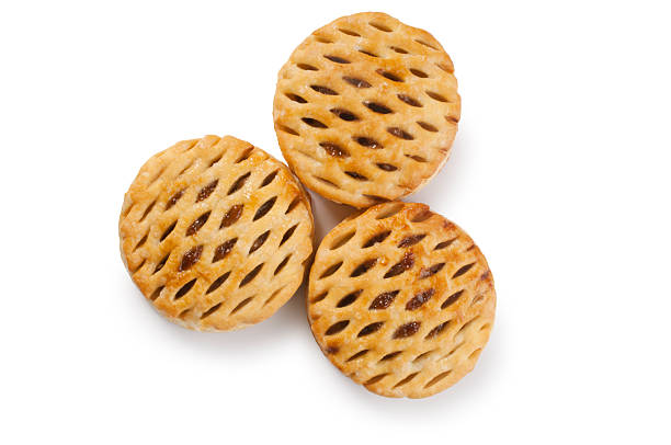 Studio shot of lattice top puff pastry mince pies cut out against a white background