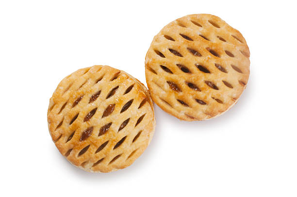 Studio shot of lattice top puff pastry mince pies cut out against a white background