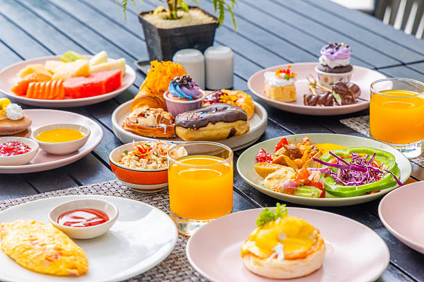 Colorful breakfast spread on table with various pastries, fruits,