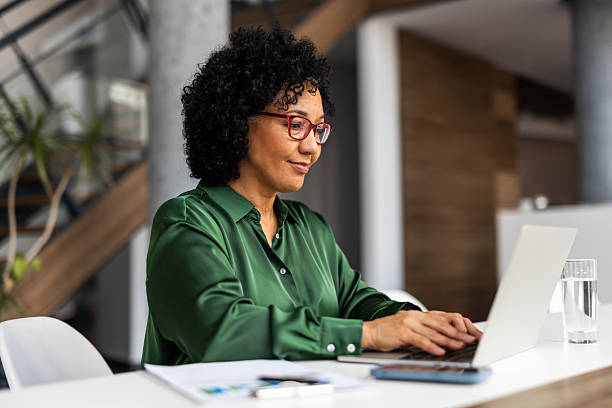 istock Professional Woman Working on Laptop in Modern Office Environment 2251598489