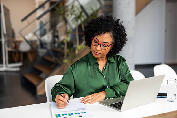 istock Professional Woman Analyzing Business Documents at Her Desk in Modern Office 2251598556