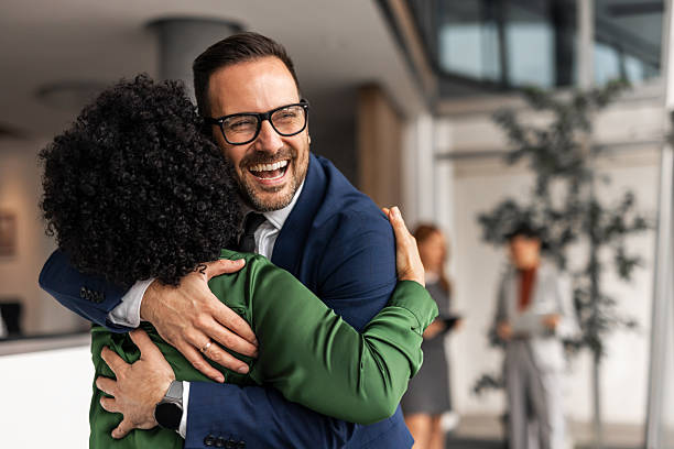 istock Two Business Professionals Embrace Happily in a Bright Office Environment 2251600072