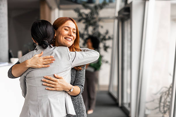 istock Two Professionals Sharing a Warm Hug in Office Space 2251600089